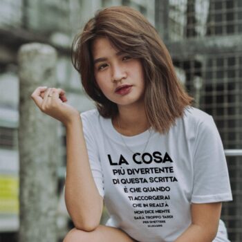 modella che indossa maglietta divertente bianca "la cosa più divertente di questa scritta è che quando ti accorgerai che in realtà non dice niente sarà troppo tardi per smettere di leggere"